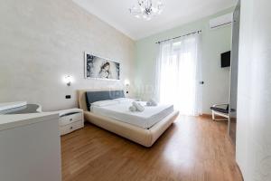 ein weißes Schlafzimmer mit einem Bett und einem Fenster in der Unterkunft CORAL BAY Apartment in Porto Cesareo