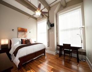 a bedroom with a bed and a desk and a window at The Valley in Vicksburg
