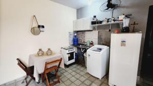 a small kitchen with a table and a refrigerator at Sao Luis Praia Studio in São Luís