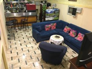 a living room with a blue couch and a bar at Hotel Bolognese in Foligno