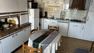 a small kitchen with a table and chairs in it at Le Tuc de Rose in Mimizan +2 photos