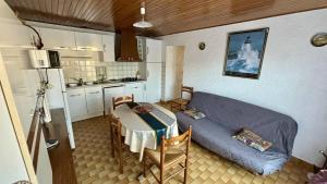 a room with a bed and a table and a kitchen at Le Tuc de Rose in Mimizan