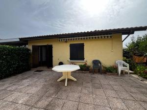 a white table and chairs in front of a house at Le Tuc de Rose in Mimizan