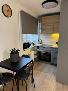 a kitchen with a table and chairs and a clock at Cozy Center Apartment in Jelgava +19 photos