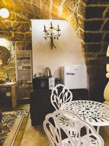 een eetkamer met een tafel en stoelen en een magnetron bij Corte Lirice Paradiso in Gioia del Colle +16 foto's