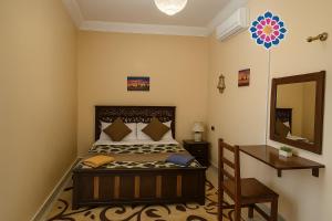 a bedroom with a bed and a desk and a mirror at Desert Dream Apartment in Merzouga