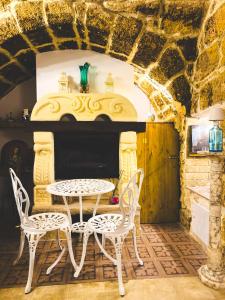 een tafel en stoelen in een kamer met een stenen muur bij Corte Lirice Paradiso in Gioia del Colle