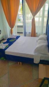 a large bed in a room with curtains at Colibri Hostel in Armenia