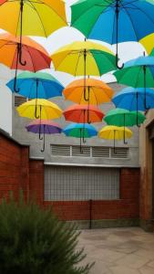 a bunch of colorful umbrellas hanging from a building at Colibri Hostel in Armenia