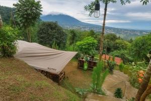 a tent on a hill with a mountain in the background at ZOYA HILLS in Pondok Cipaseban