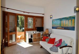a living room with a white couch and a television at Casa Simon tra mare e natura in Sperlonga