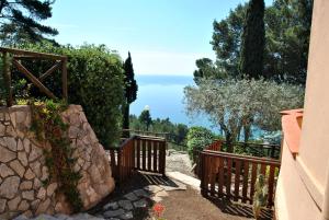 a stairway with a wooden fence and a stone wall at Casa Simon tra mare e natura in Sperlonga