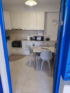 a kitchen with white cabinets and a table and chairs at Studio B1 in Mytilene +50 photos