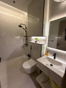 ein Badezimmer mit Toilette, Waschbecken und Spiegel in der Unterkunft منوة المساكن in Quai