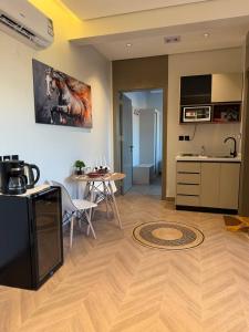 ein Wohnzimmer mit Küche und einem Tisch mit einem Pferdegemälde in der Unterkunft منوة المساكن in Quai
