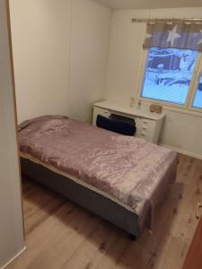 una camera da letto con un letto, una scrivania e una finestra di Aurora house a Rovaniemi