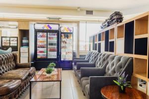 カラマにあるHotel Modular Express Calamaのソファとドリンク冷蔵庫のある待合室