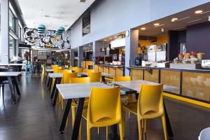 カラマにあるHotel Modular Express Calamaの黄色い椅子とテーブル、カウンター付きのレストラン +22枚の写真
