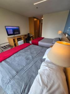 a hotel room with two beds and a television at Flat 1015 - Comfort Hotel Taguatinga in Brasilia +26 photos