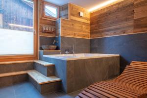 un baño con bañera y lavabo en Stadel Alpenstern mit Wellnessbereich, en Blitzingen