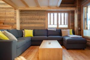 Una sala de estar con un sofá azul y una mesa de café. en Stadel Alpenstern mit Wellnessbereich, en Blitzingen