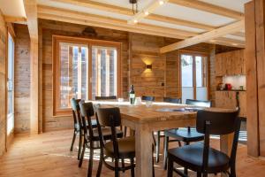 Un comedor con mesa y sillas de madera. en Stadel Alpenstern mit Wellnessbereich, en Blitzingen