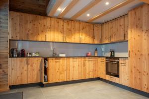 cocina grande con armarios y electrodomésticos de madera en Stadel Alpenstern mit Wellnessbereich, en Blitzingen 37 fotos más