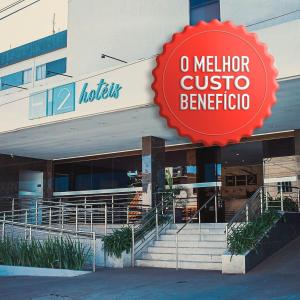 um hotel com um sinal vermelho em frente a um edifício em Hotel H2 Congonhas em Congonhas