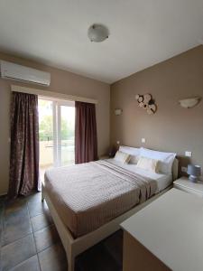 een slaapkamer met een groot bed en een raam bij Ilios Mare Hotel in Agia Marina Nea Kydonias +35 foto's