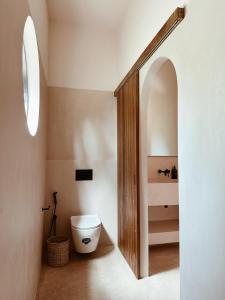 een badkamer met een toilet en een houten deur bij Together Boutique Villa in Ahangama +26 foto's