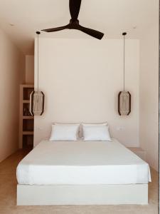 een slaapkamer met een wit bed met een plafondventilator bij Together Boutique Villa in Ahangama