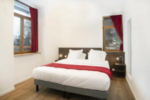 Un dormitorio con una cama grande con cortinas rojas. en Auberge de Morcles, en Morcles