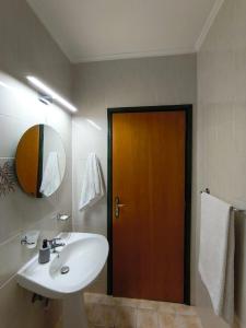 een badkamer met een wastafel en een houten deur bij Ilios Mare Hotel in Agia Marina Nea Kydonias
