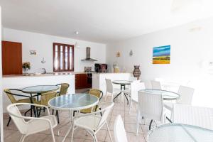 een keuken en eetkamer met tafels en stoelen bij Giorni Salentini in Torre Lapillo +25 foto's