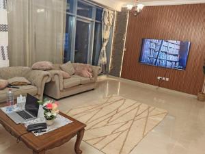 un soggiorno con un divano e un tavolo con un computer portatile di Ajman Corniche Residence ad Ajman