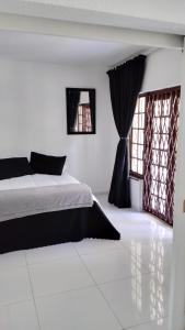 een slaapkamer met een bed en twee ramen bij 115 Eden wilds in Port Edward