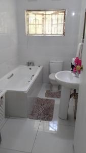 een witte badkamer met een bad en een wastafel bij 115 Eden wilds in Port Edward