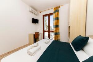 een slaapkamer met een bed met handdoeken erop bij Giorni Salentini in Torre Lapillo