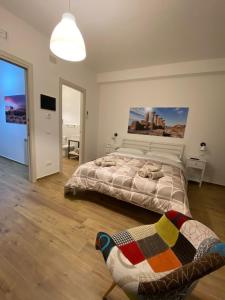 um quarto com uma cama e uma pintura na parede em Tra Mare e Mito em Agrigento