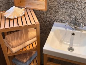 a bathroom with a sink and a shelf with towels at Fiskerhytte - Meine Fischerhütte in Börgerende-Rethwisch +133 photos