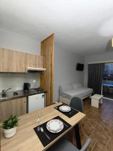 een keuken en een eetkamer met een tafel en een keuken bij Ilios Mare Hotel in Agia Marina Nea Kydonias