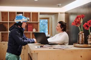 a man and a woman sitting at a table with a laptop at Appartement Omesberg 1 in Lech am Arlberg