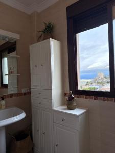 een badkamer met een witte kast en een raam bij Apartamento La Constitución in Luque