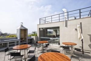 d'une terrasse sur le toit avec des tables et des chaises. dans l'établissement Wasi Apartment Pardo, à Lima