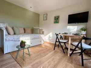 a living room with a couch and a table with chairs at Studio tout confort dans la campagne aixoise in Le Puy-Sainte-Réparade