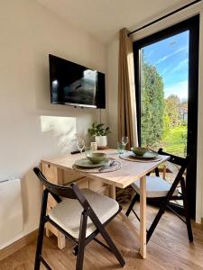 a dining room with a table with two chairs and a window at Studio tout confort dans la campagne aixoise in Le Puy-Sainte-Réparade