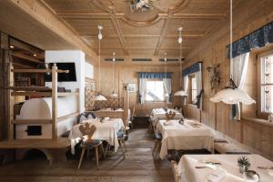 a dining room with tables and chairs and wooden walls at Muliné Lodge in Selva di Val Gardena