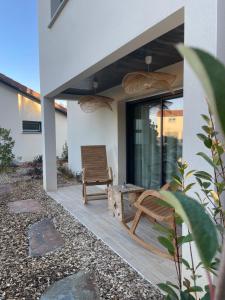 eine Terrasse mit einer Bank und einem Stuhl auf einem Haus in der Unterkunft Domaine Coul'eau in Eaunes