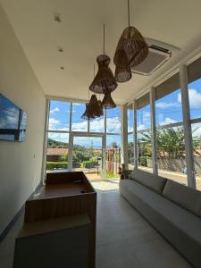 ein Wohnzimmer mit einem Sofa und großen Fenstern in der Unterkunft Pousada Village Premiere in Fernando de Noronha