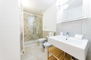 a white bathroom with a sink and a toilet at InCentro b&b in Porto Cesareo